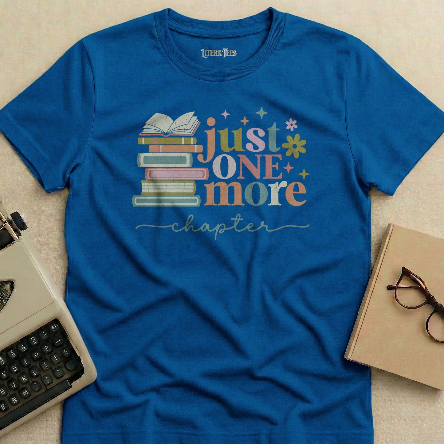 Blue t-shirt with "just ONE more chapter" and stacked books design.