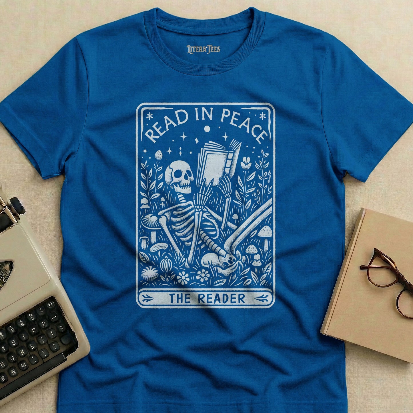 Blue t-shirt with "Read in Peace The Reader" text and skeleton reading a book.