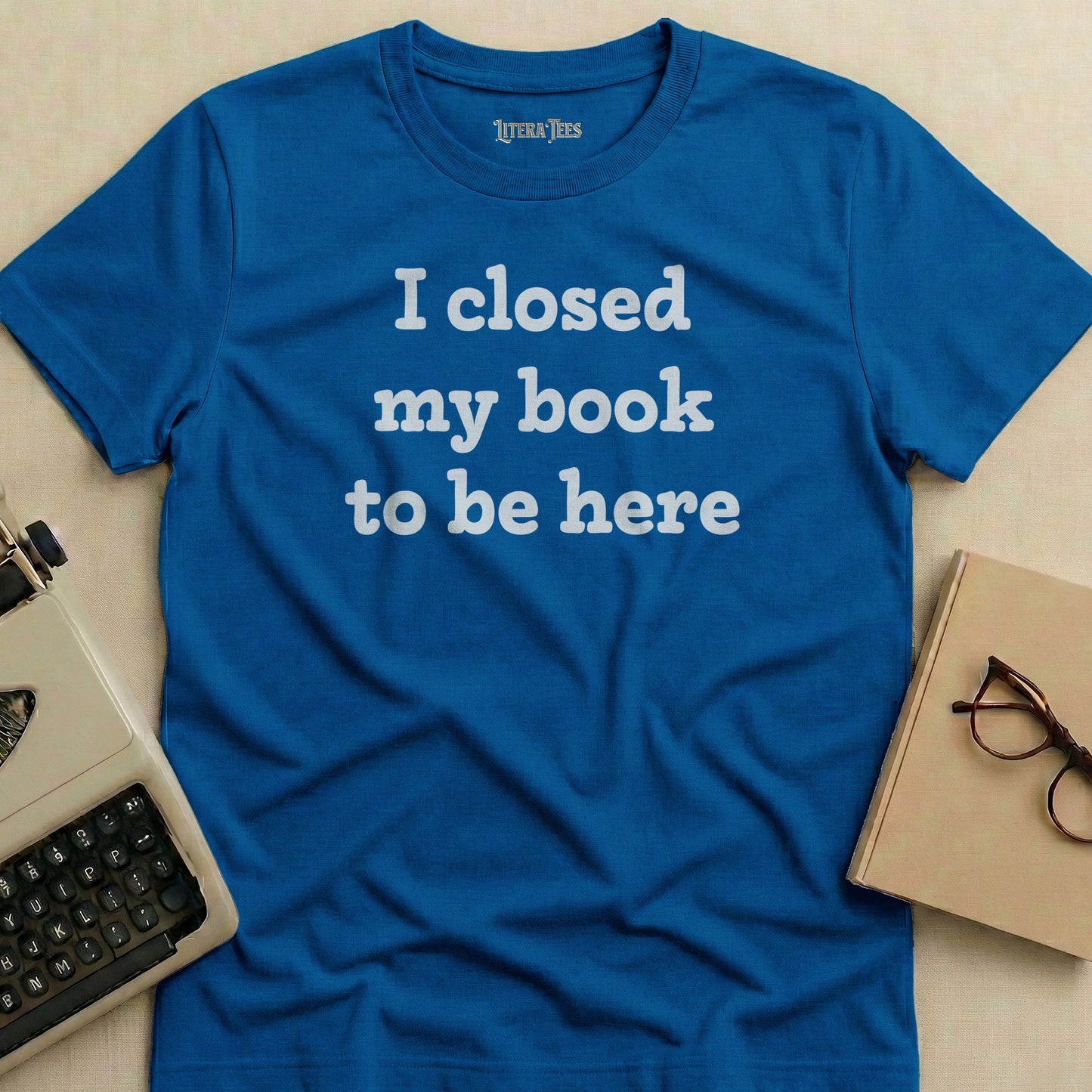 Blue t-shirt with "I closed my book to be here" text.