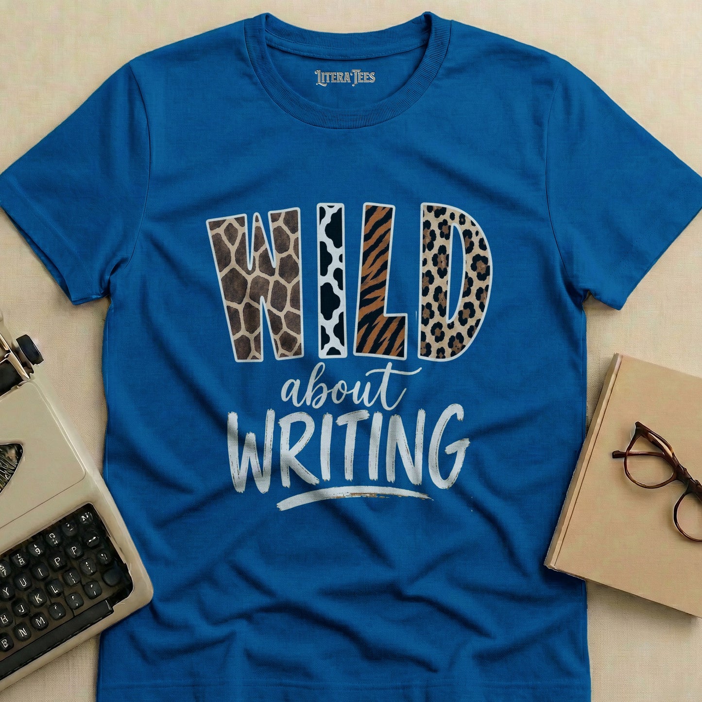 Blue t-shirt with "WILD about WRITING" text in animal print and white lettering.