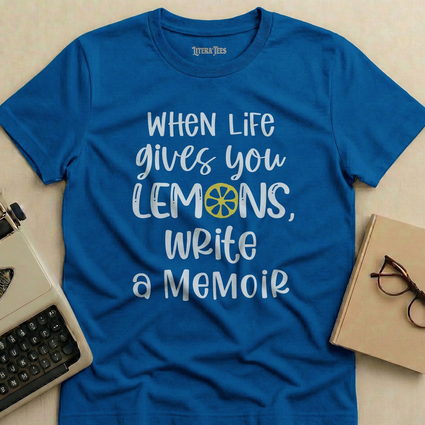 Blue t-shirt with "When life gives you lemons, write a memoir" text.