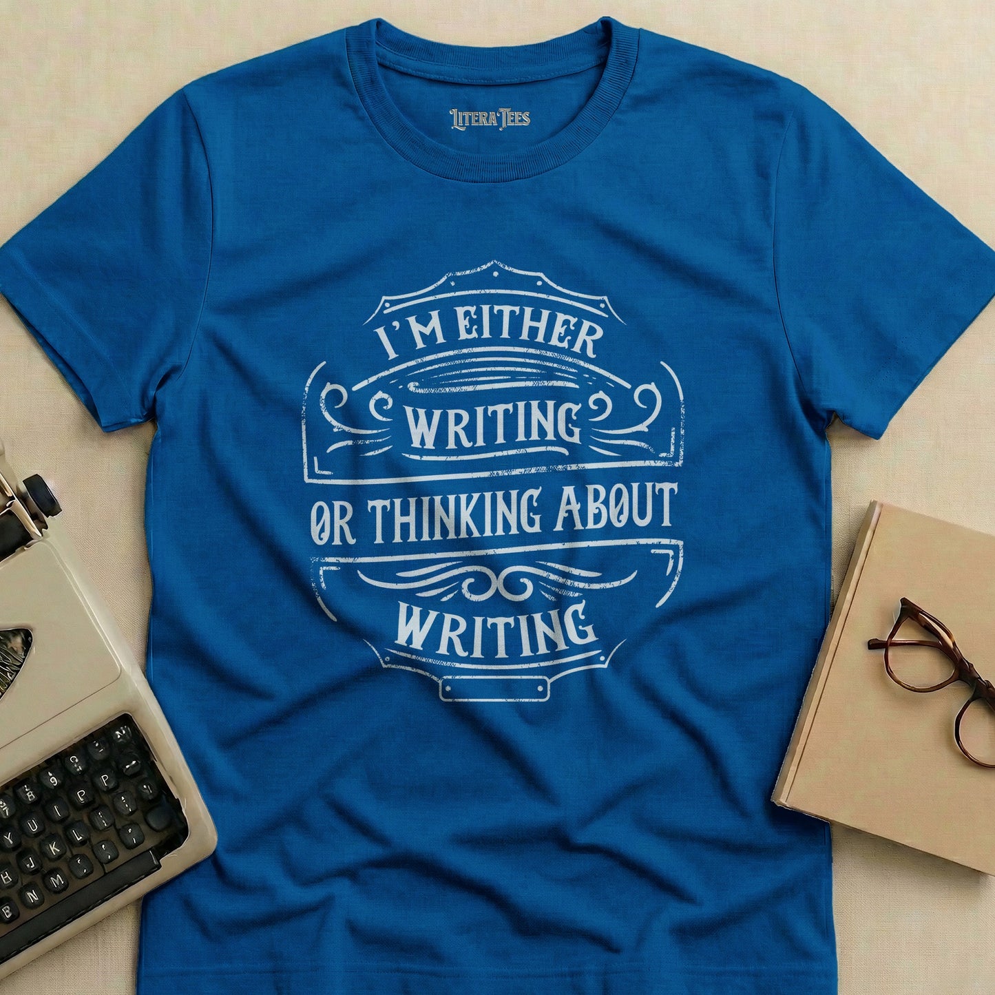 Blue t-shirt with "I'm either writing or thinking about writing" text design.