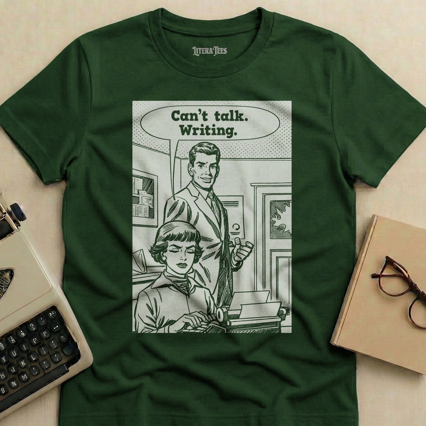 Green t-shirt with a retro comic panel featuring a woman typing and a man speaking "Can't talk. Writing."