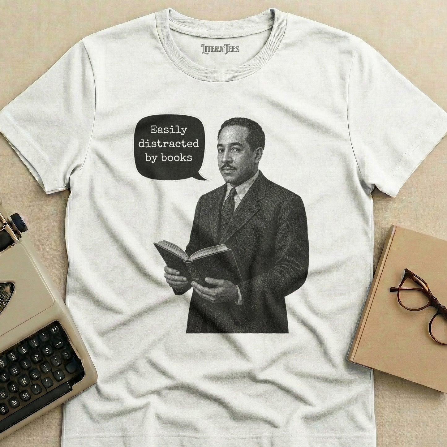 White t-shirt with black graphic of a man reading a book, saying "Easily distracted by books".