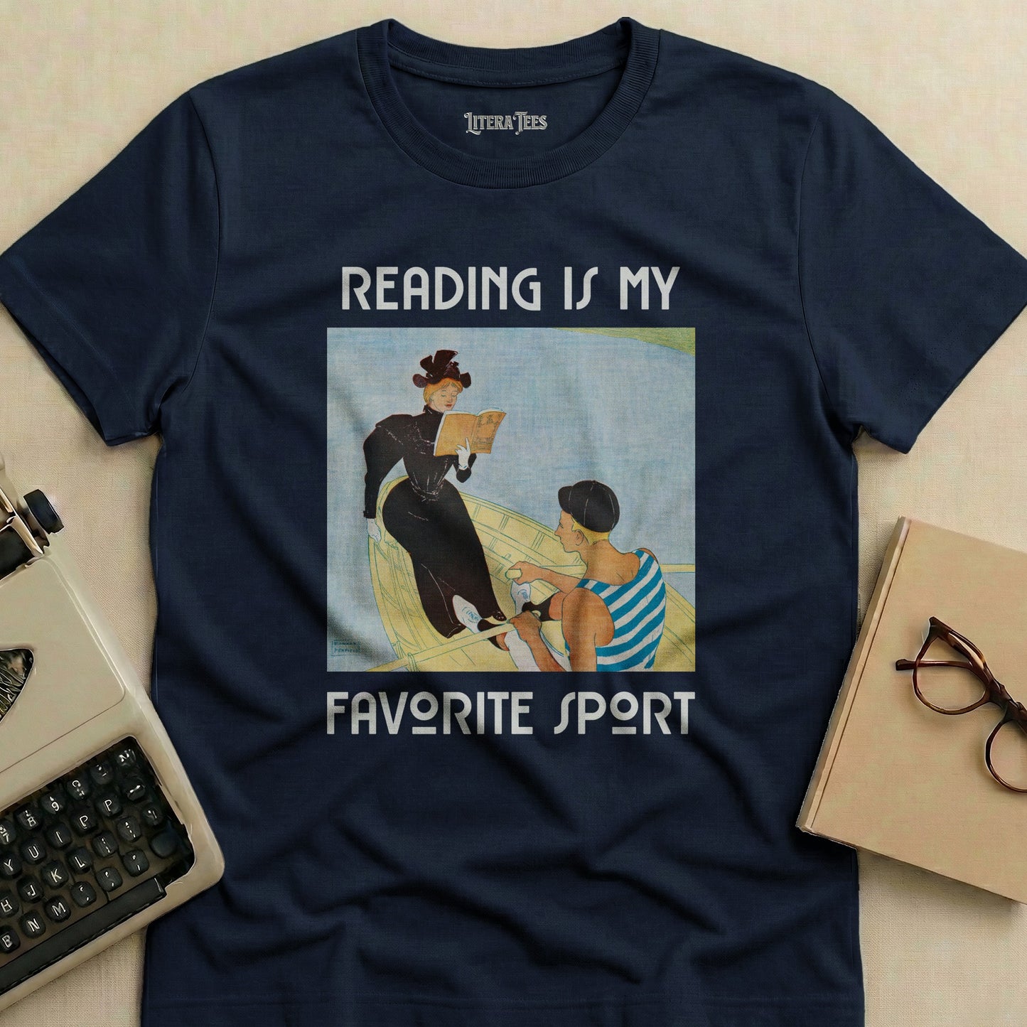 Navy t-shirt with "READING IS MY FAVORITE SPORT" text and a painting of two women reading in a boat.