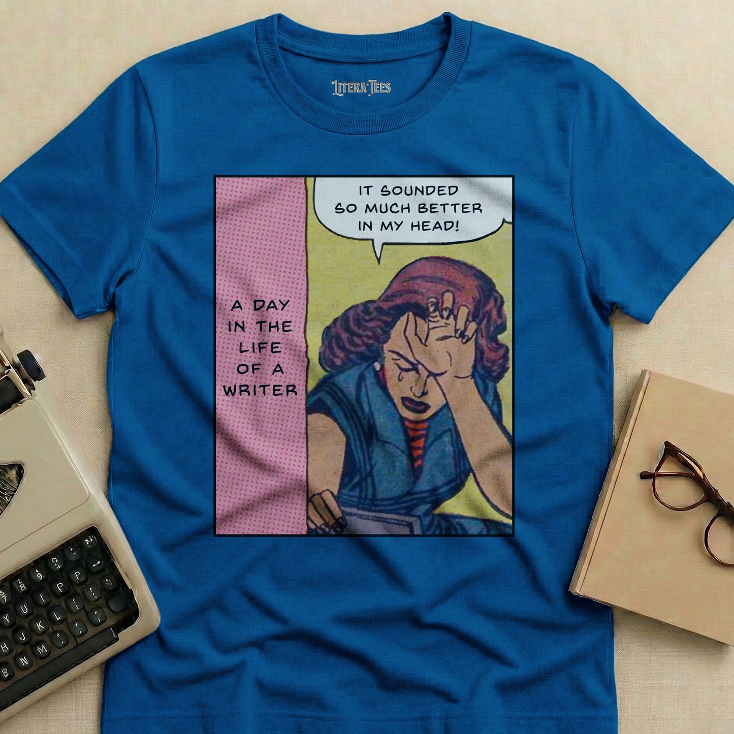 Blue t-shirt with comic panel: crying writer, text "A Day in the Life of a Writer".