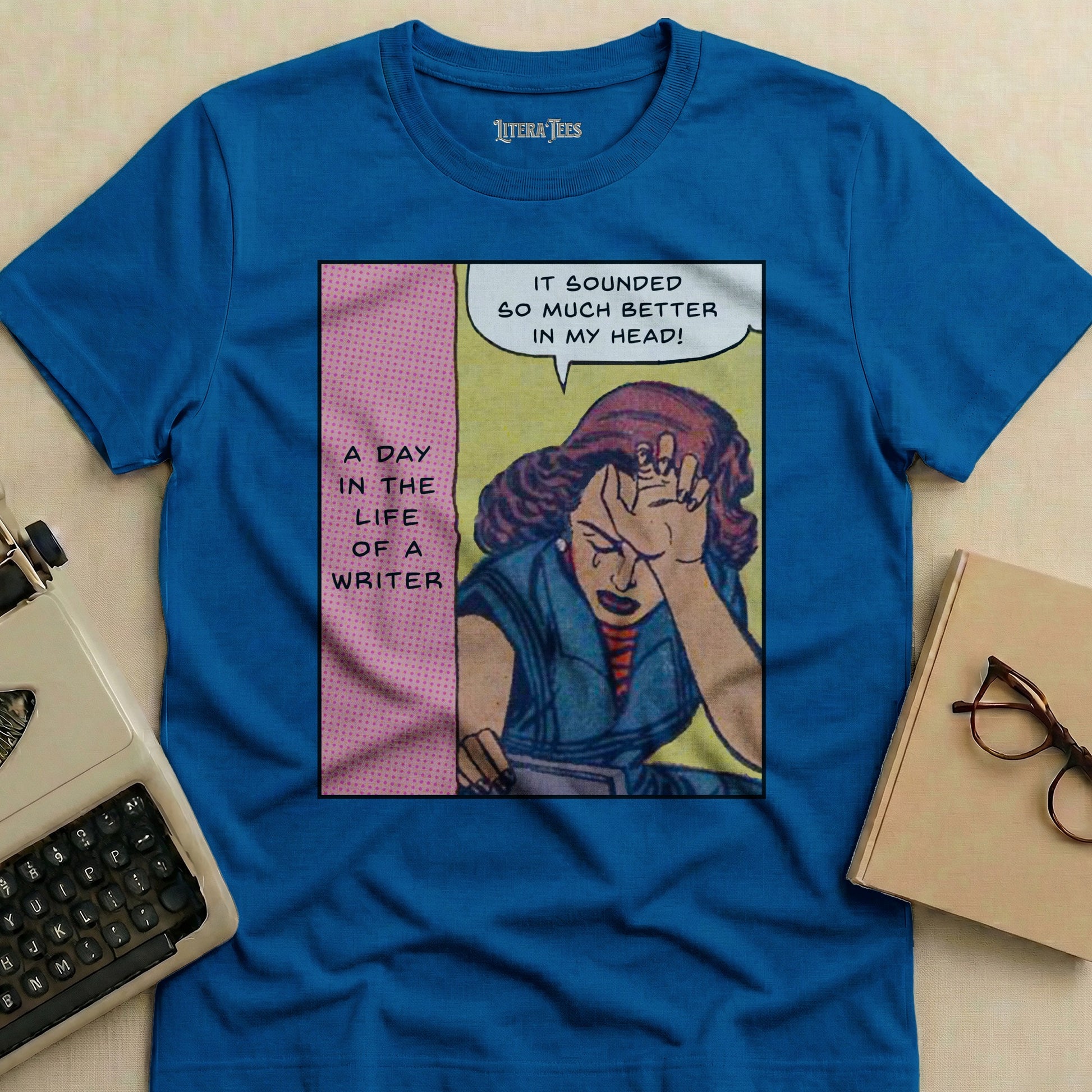 Blue t-shirt with comic panel: crying writer, text "A Day in the Life of a Writer".