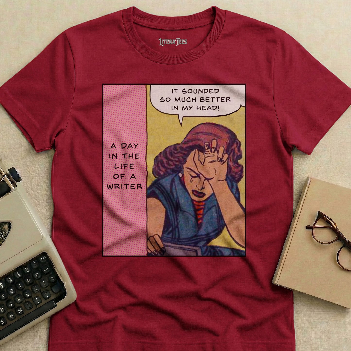 Maroon t-shirt with comic art of a distressed woman and text: "A Day in the Life of a Writer. It sounded so much better in my head!"