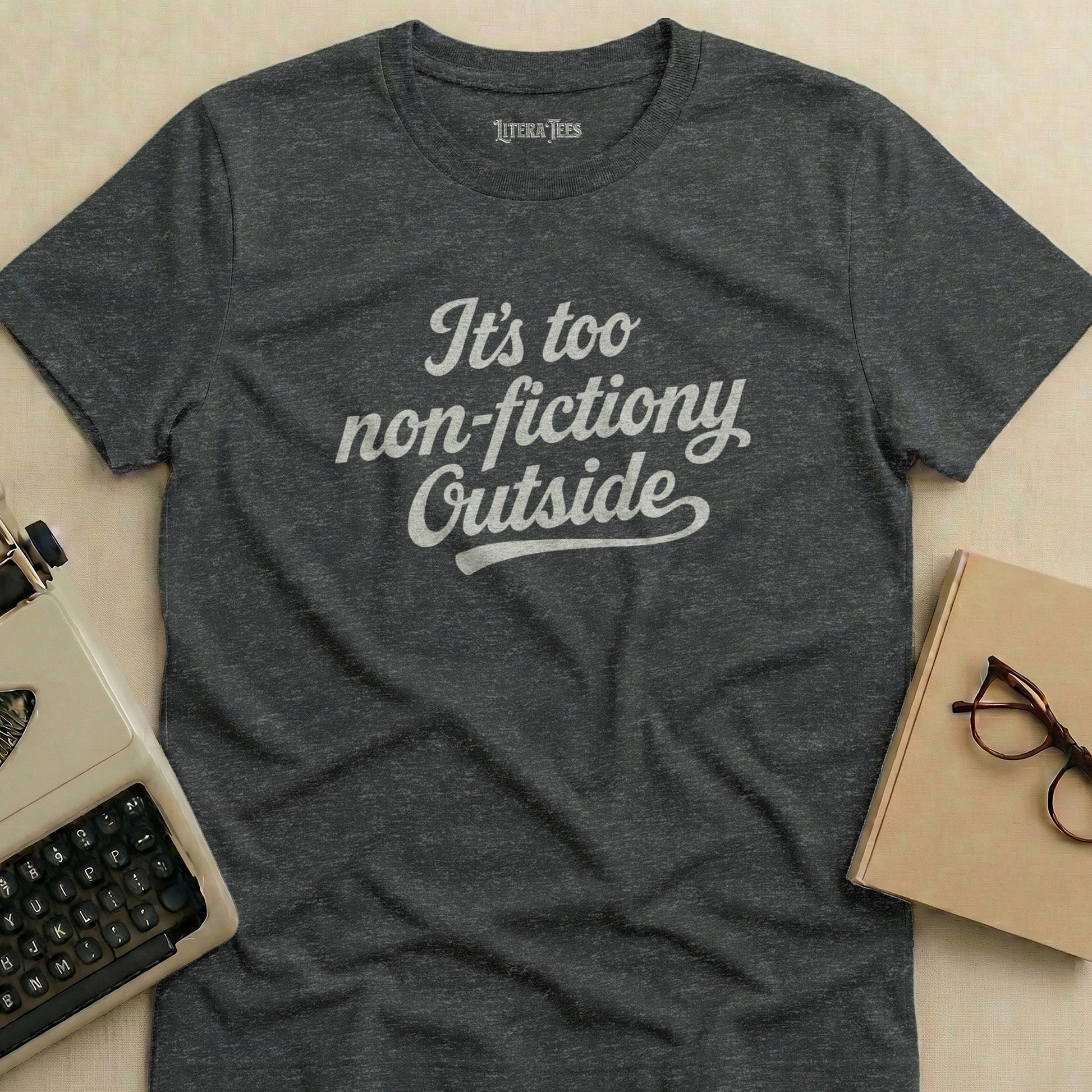 Dark grey t-shirt with white text "It's too non-fictiony Outside."