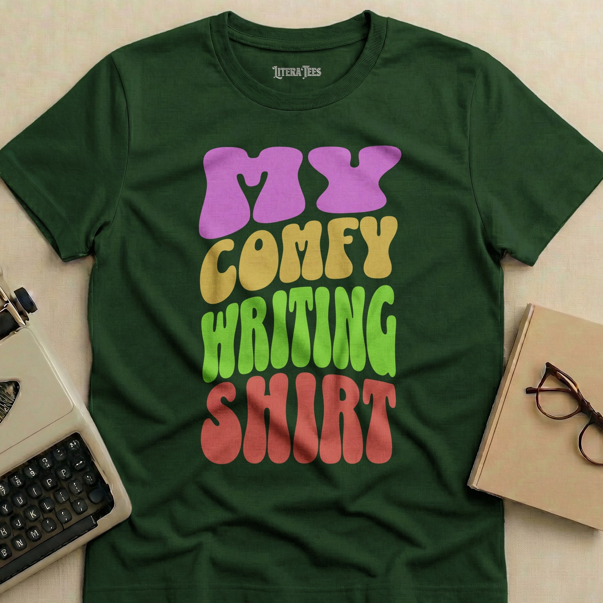 Dark green t-shirt with "MY COMFY WRITING SHIRT" text in colorful letters.