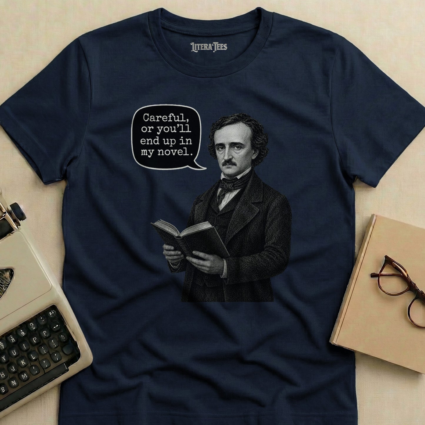 Edgar Allan Poe on a navy shirt next to a typewriter and glasses.