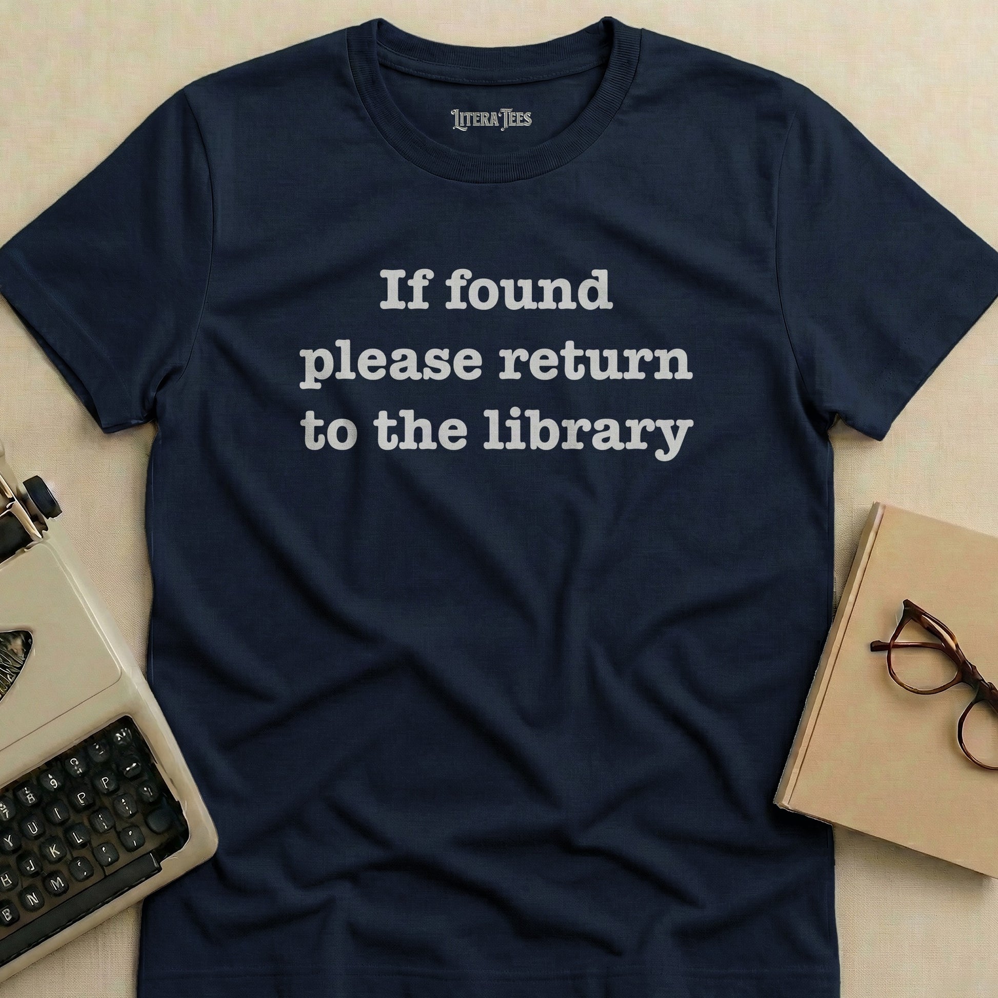 Navy t-shirt with white text reading "If found please return to the library".