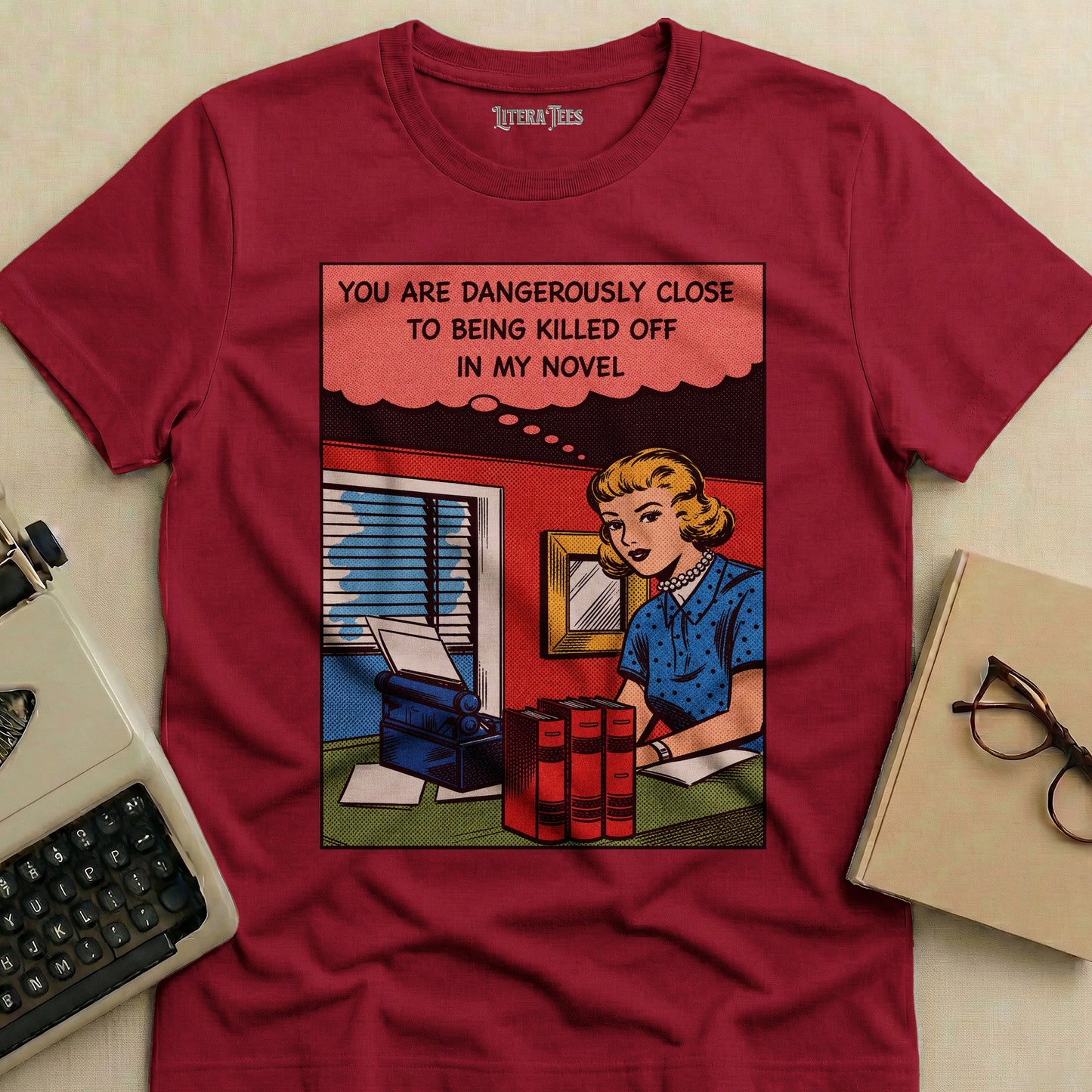 T-shirt with comic panel of woman at desk with typewriter and books.