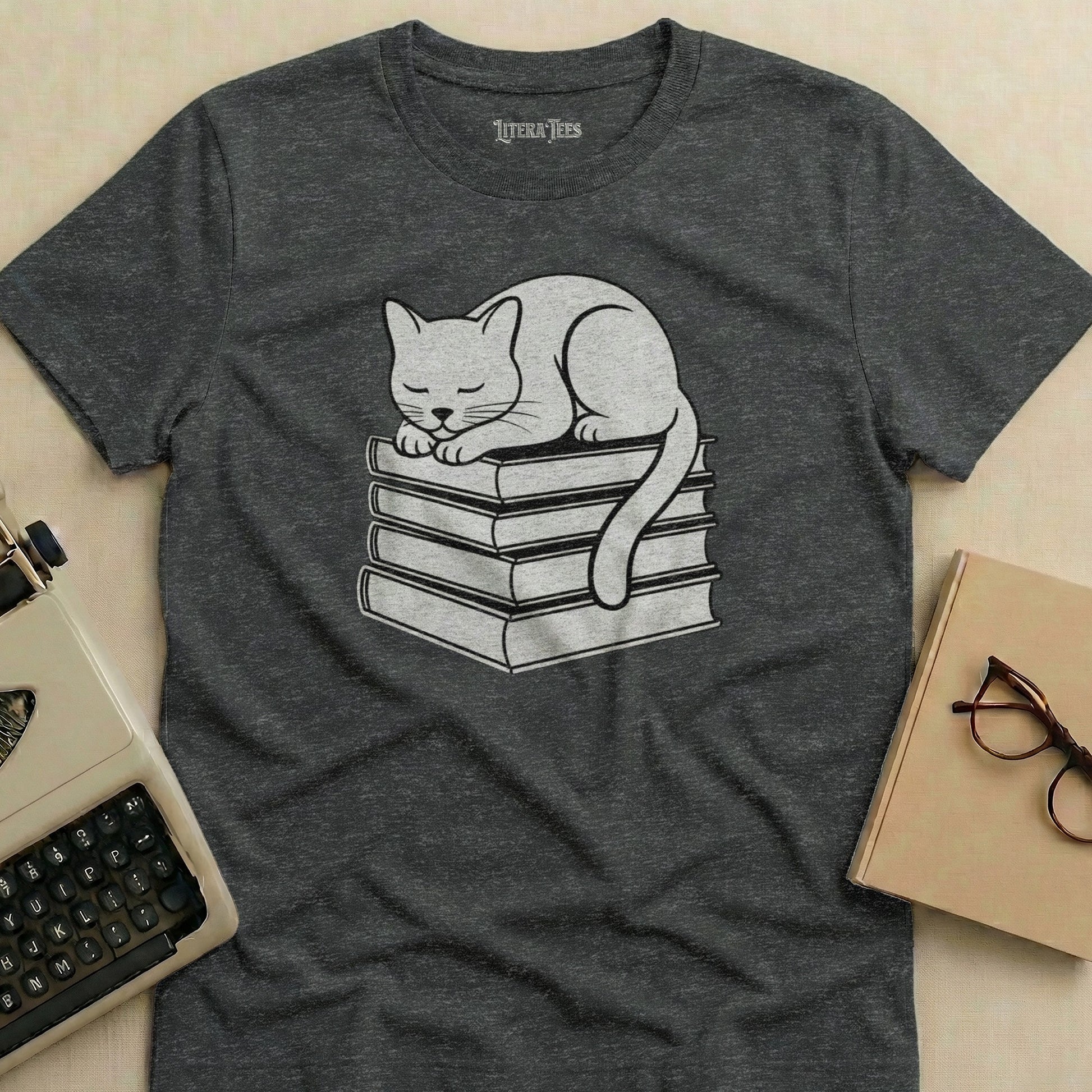 Grey t-shirt with a sleeping cat on a stack of books design.