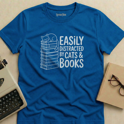 Blue t-shirt with white text "Easily Distracted By Cats & Books" and a cat on books.