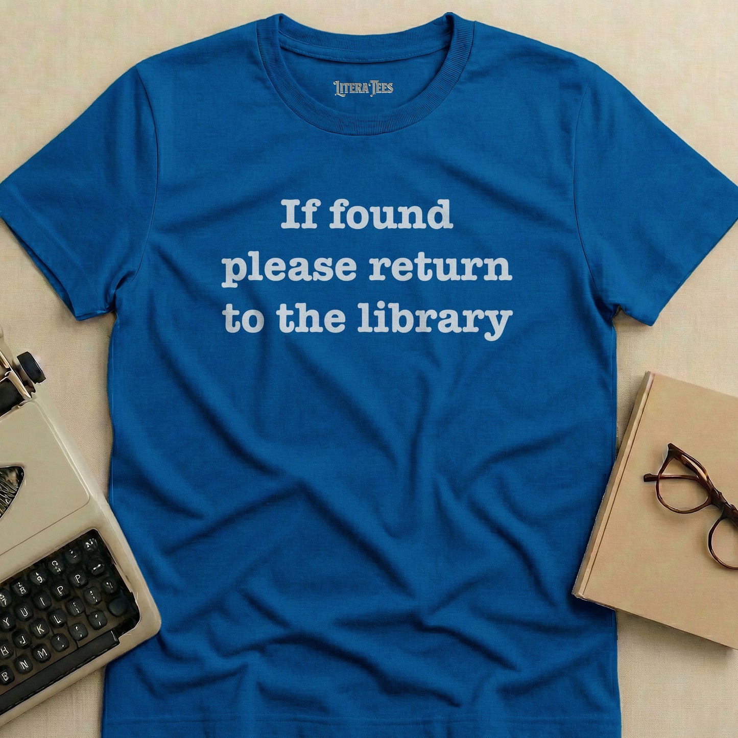 Blue t-shirt with "If found please return to the library" text.