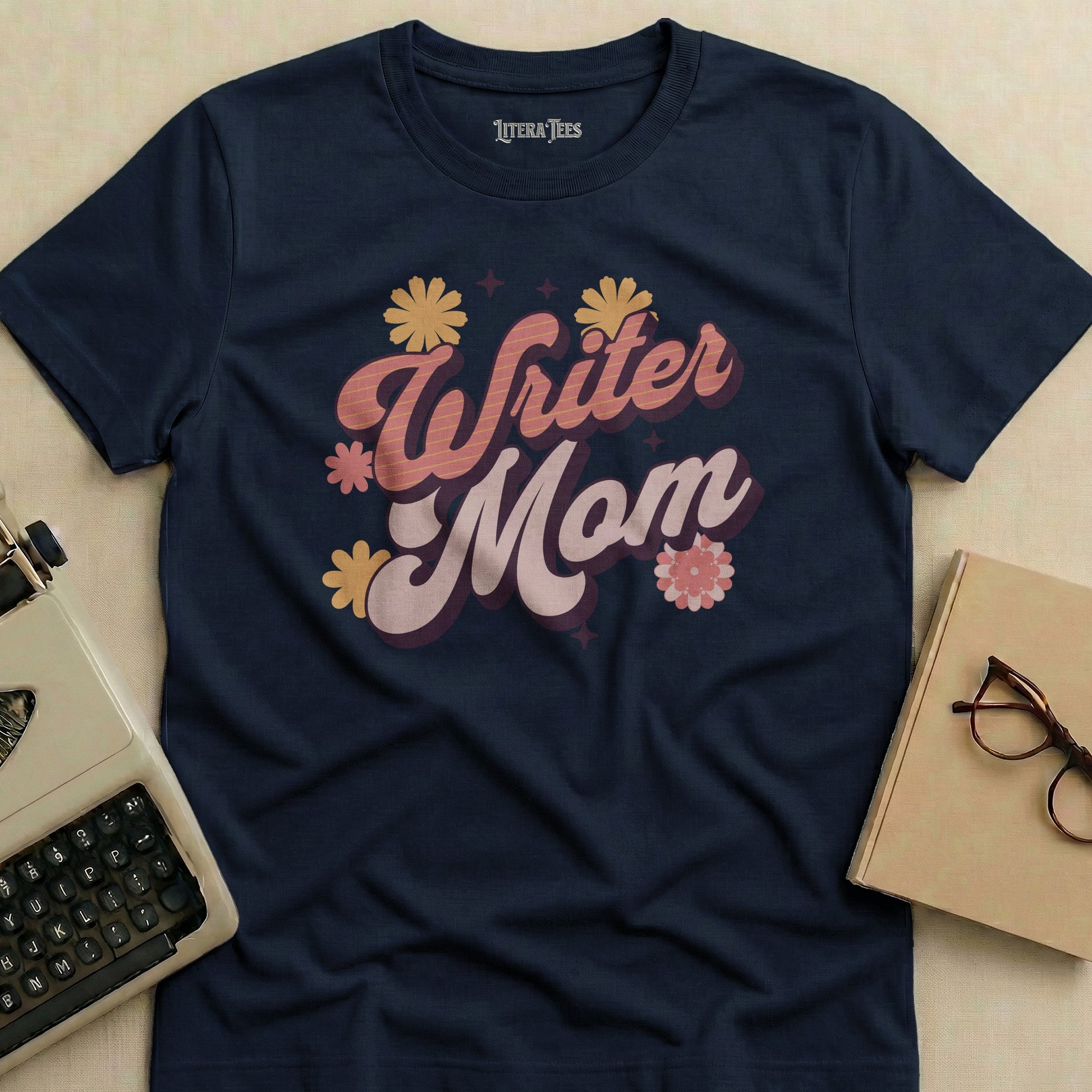 Navy t-shirt with "Writer Mom" in retro font and floral accents.