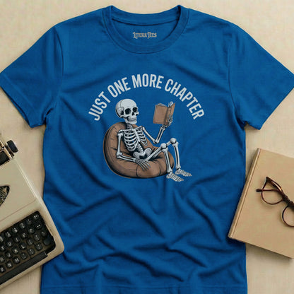 Blue t-shirt with "Just One More Chapter" text and skeleton reading a book.