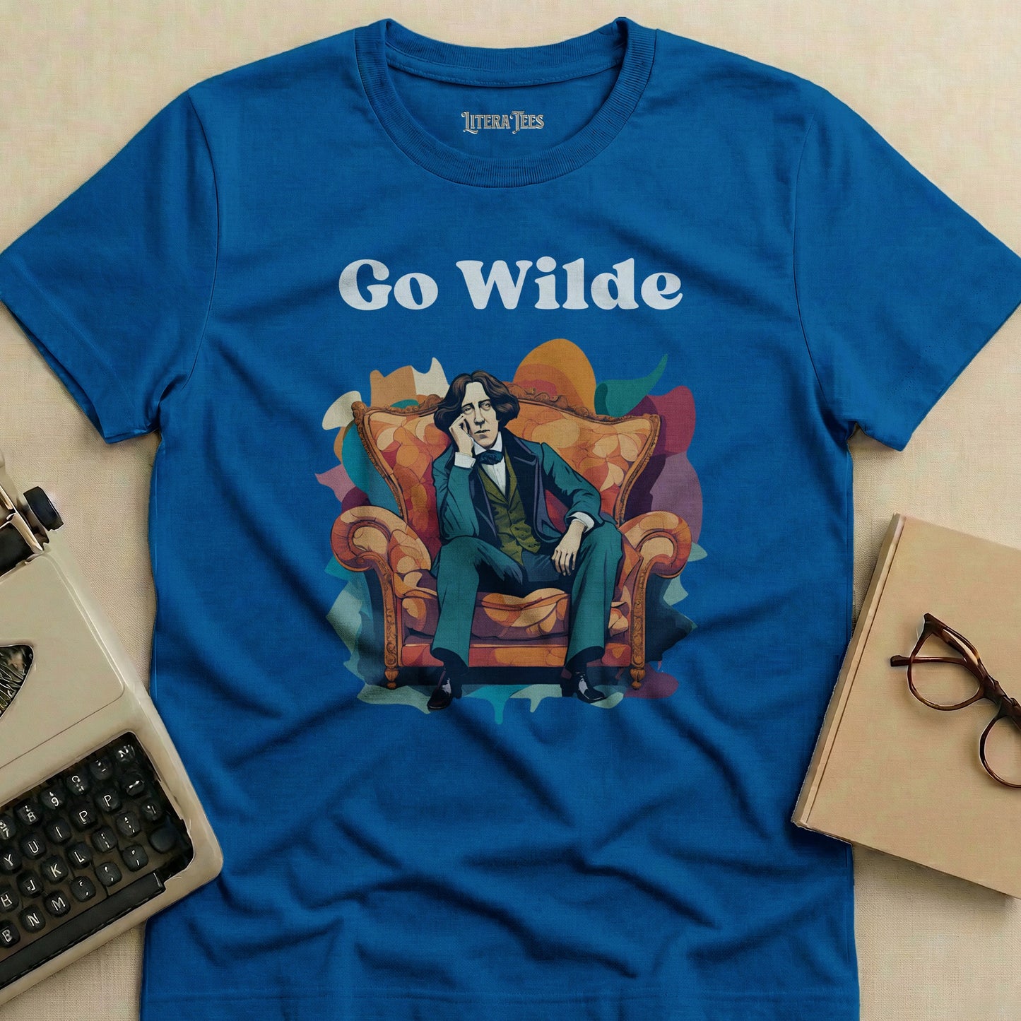 Blue t-shirt with "Go Wilde" text and illustration of Oscar Wilde seated.