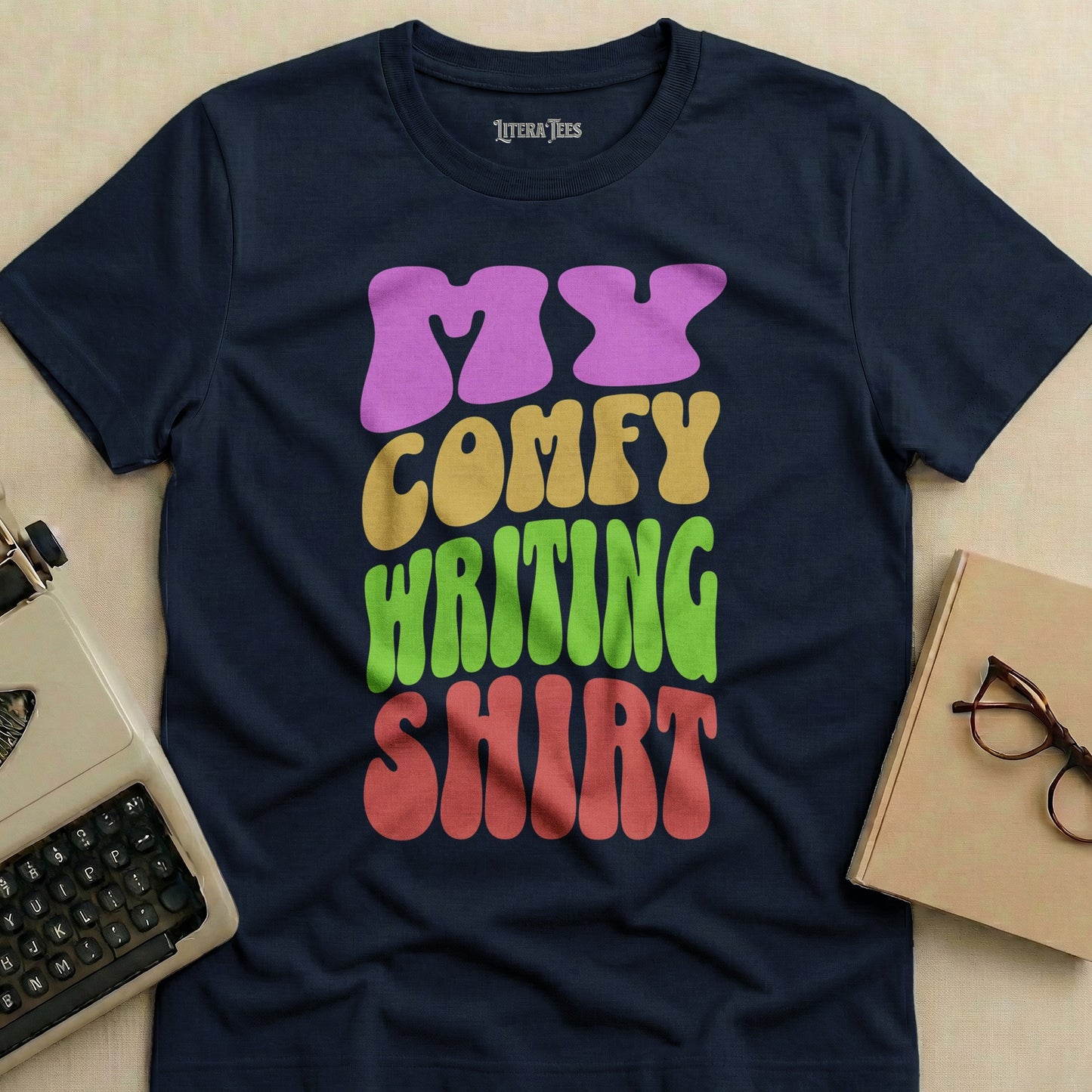 Navy t-shirt with "MY COMFY WRITING SHIRT" in colorful wavy text.