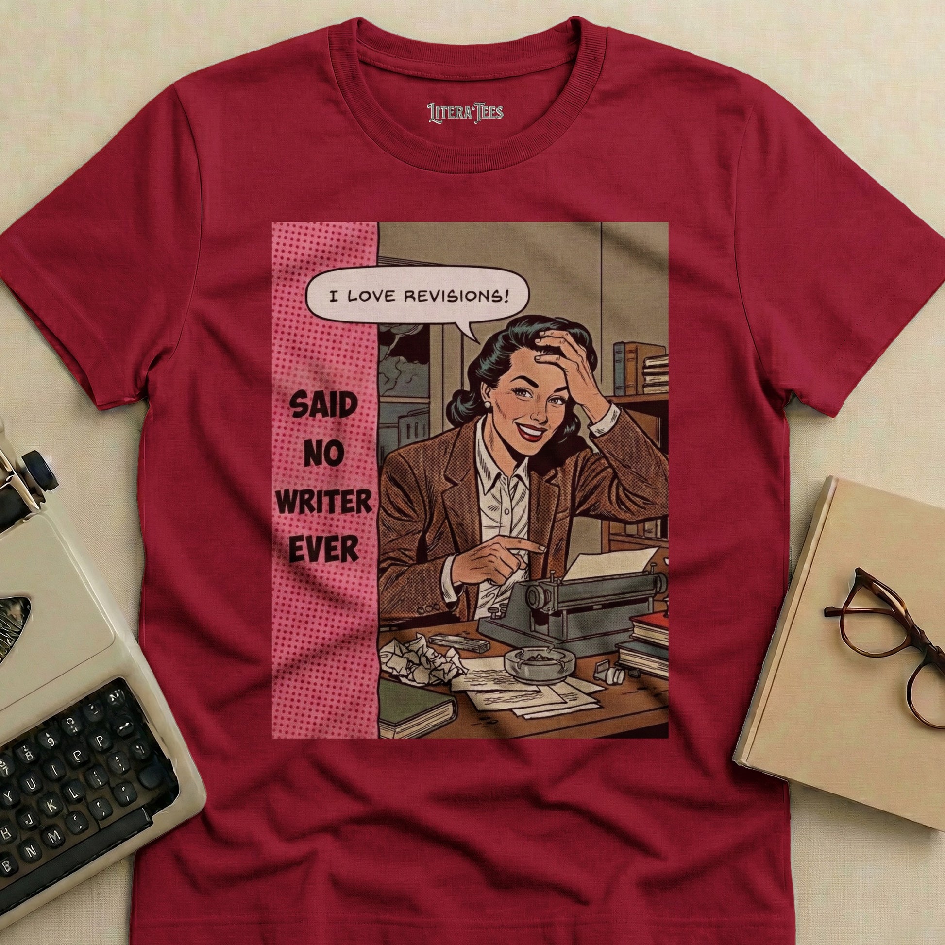 Maroon t-shirt with comic art of a woman at a typewriter saying "I love revisions!"