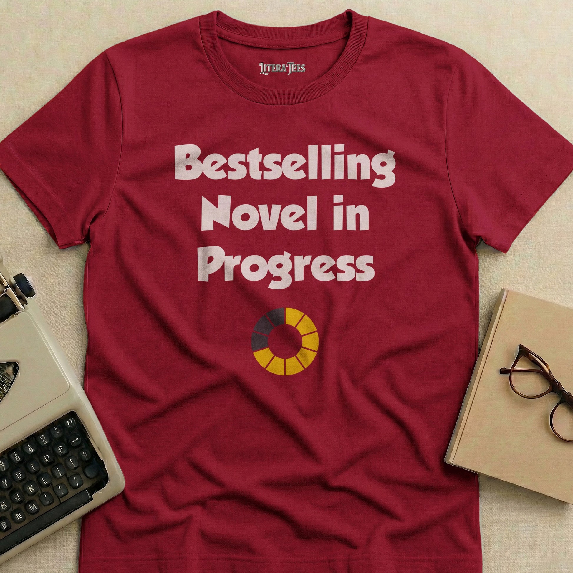 Burgundy t-shirt with "Bestselling Novel in Progress" text and progress circle.