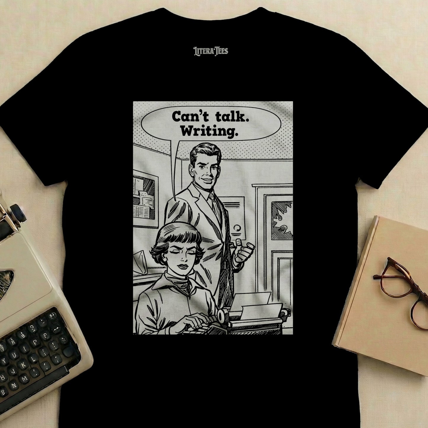 T-shirt graphic: man gestures to woman typing, saying "Can't talk. Writing."