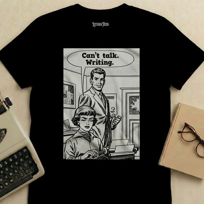 T-shirt graphic: man gestures to woman typing, saying "Can't talk. Writing."