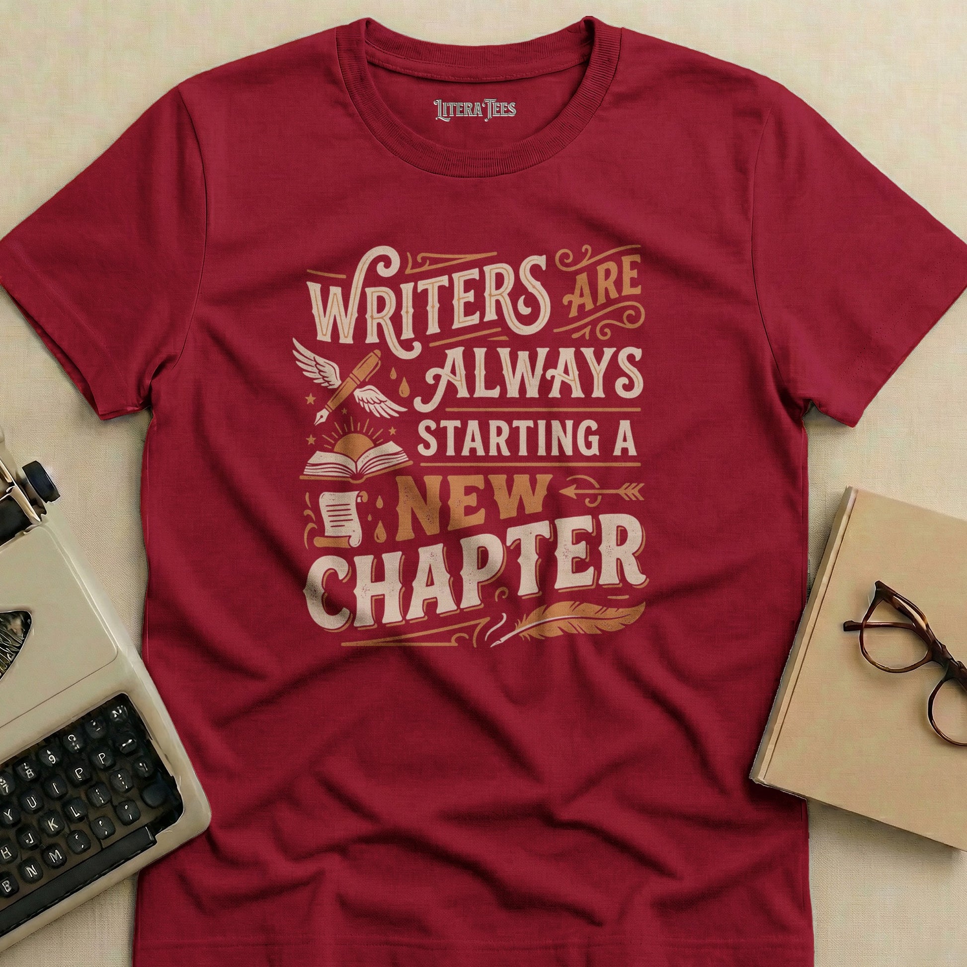 Maroon t-shirt with "Writers Are Always Starting a New Chapter" text and illustrations.