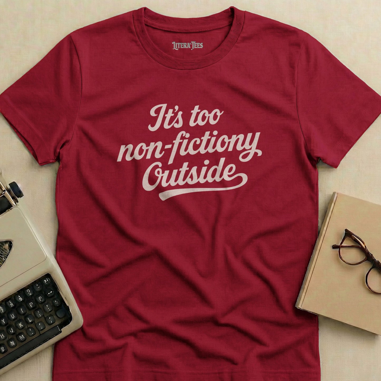 Burgundy t-shirt with white text "It's too non-fictiony Outside".