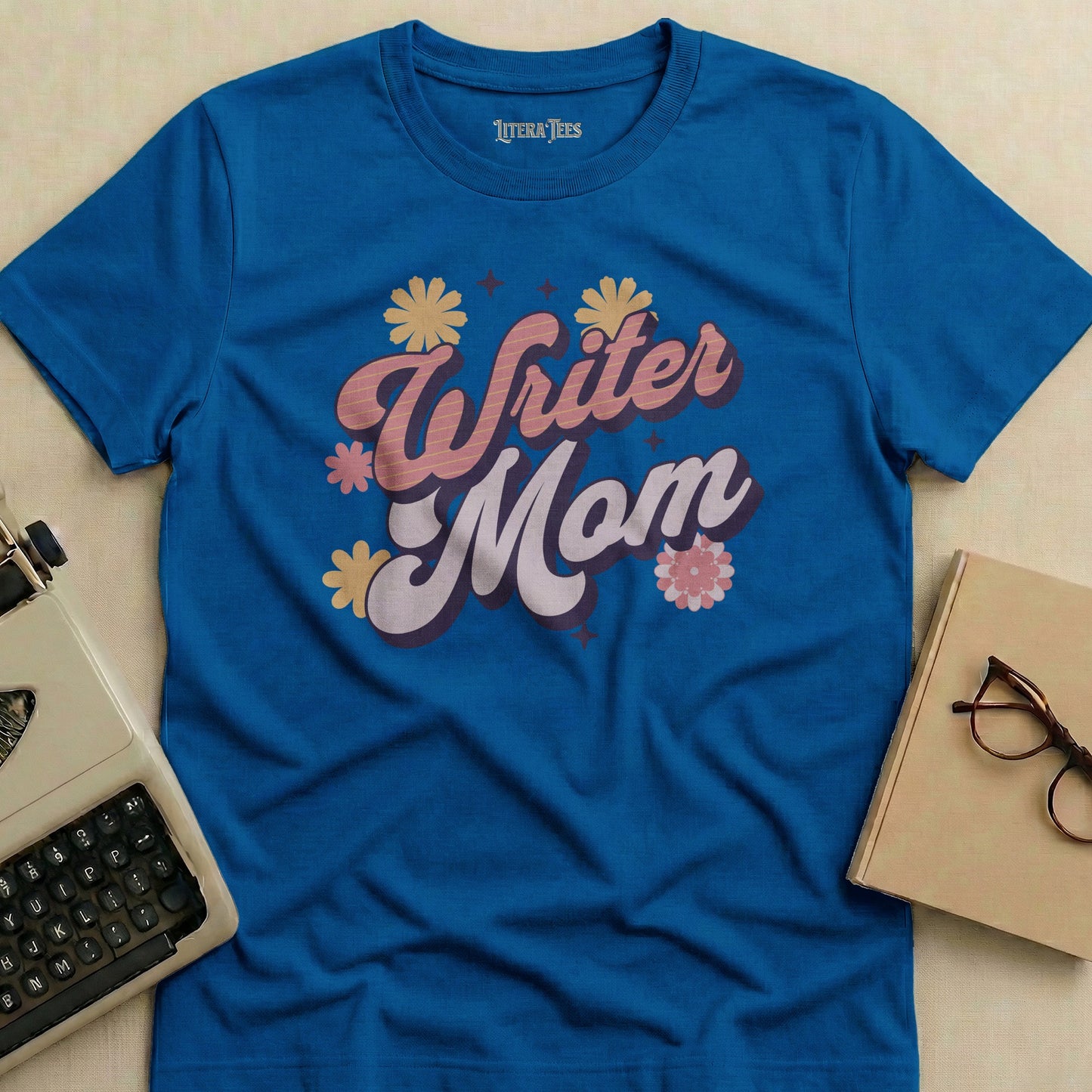 Blue t-shirt with "Writer Mom" text in retro floral font.