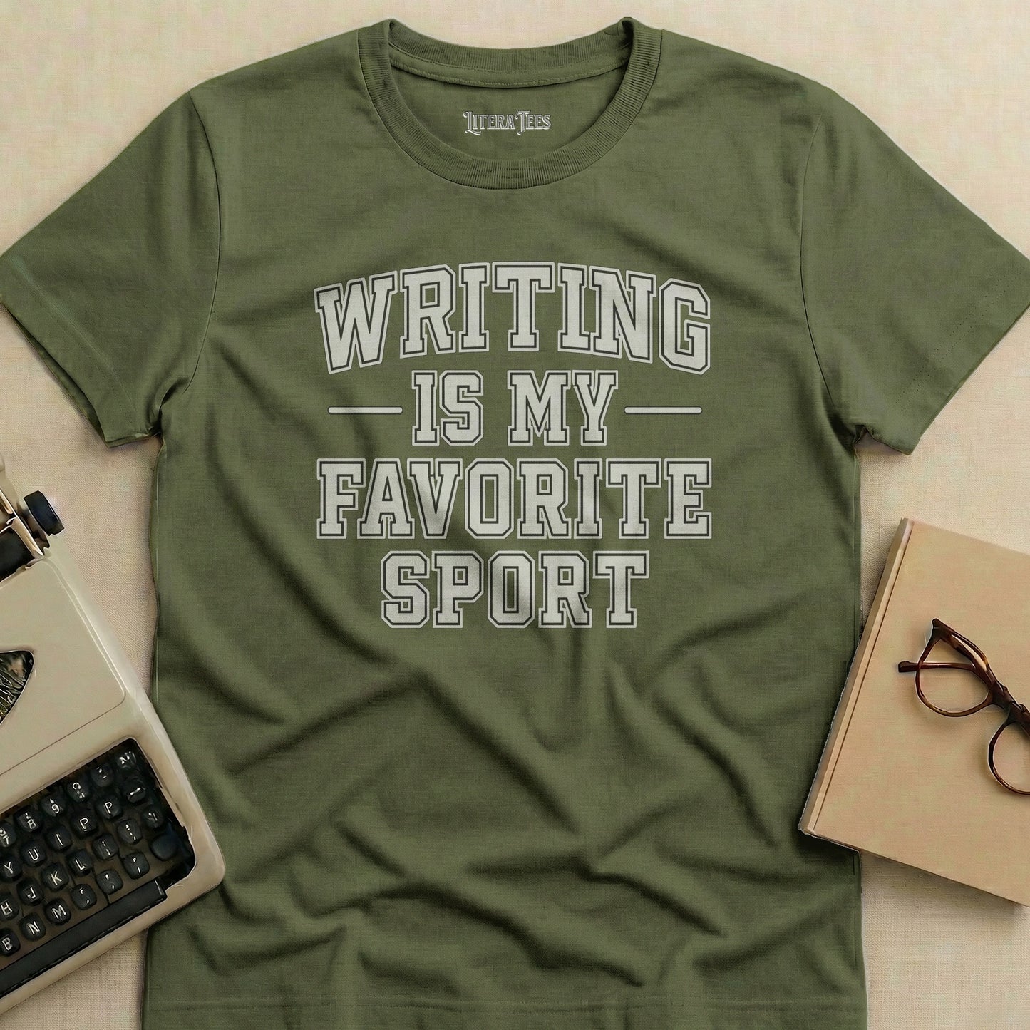 Olive green t-shirt with "WRITING IS MY FAVORITE SPORT" text.