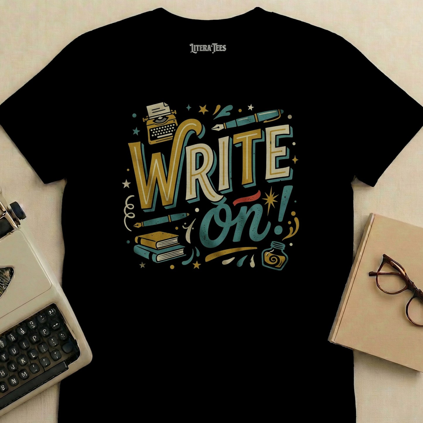 Black t-shirt with "WRITE on!" in colorful lettering, vintage typewriter, and books.