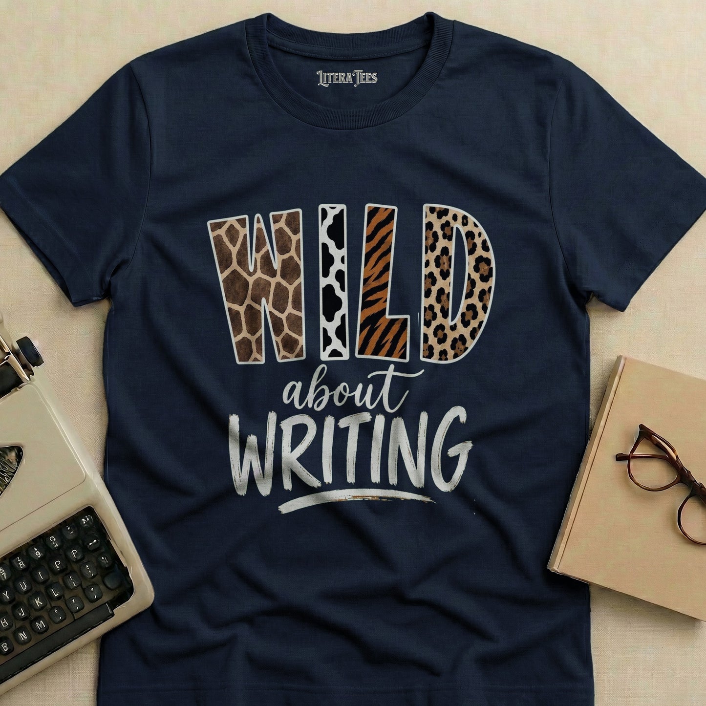 Navy t-shirt with "WILD about WRITING" in animal print and distressed text.