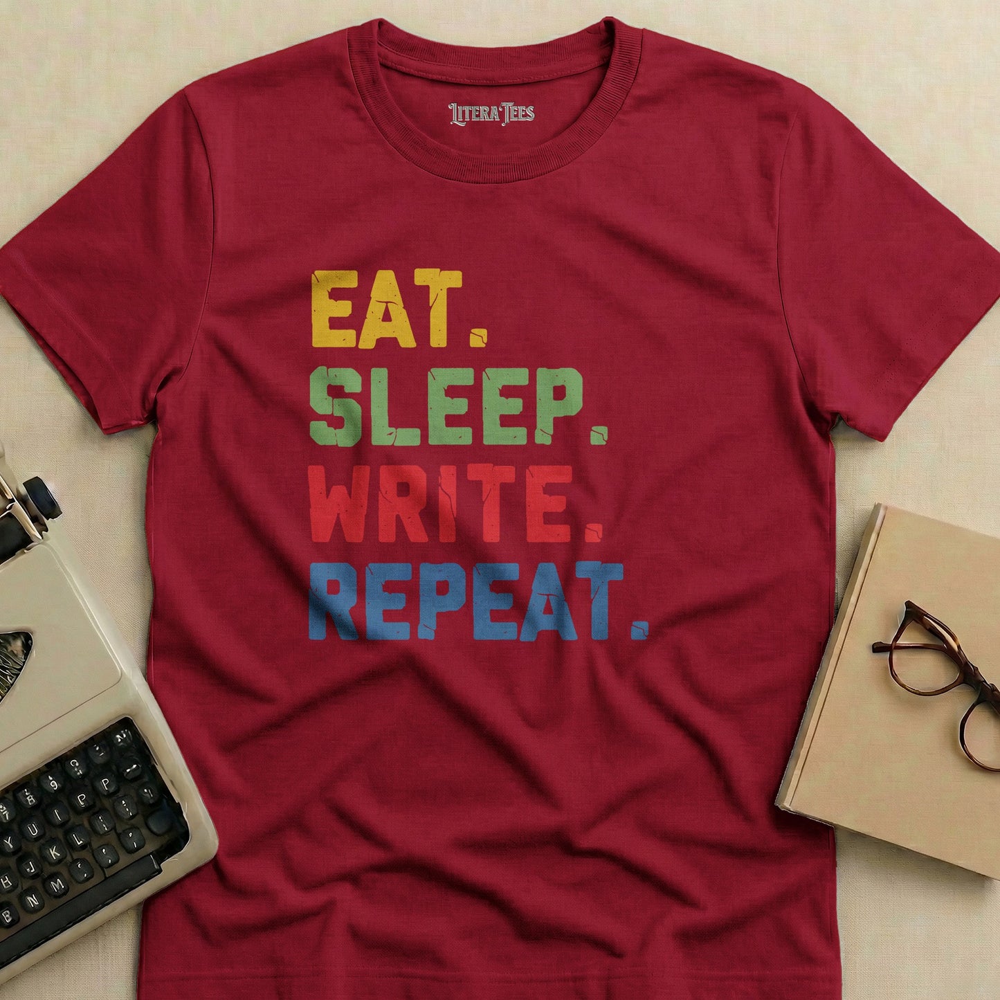 Maroon t-shirt with "EAT. SLEEP. WRITE. REPEAT." in colorful block letters.