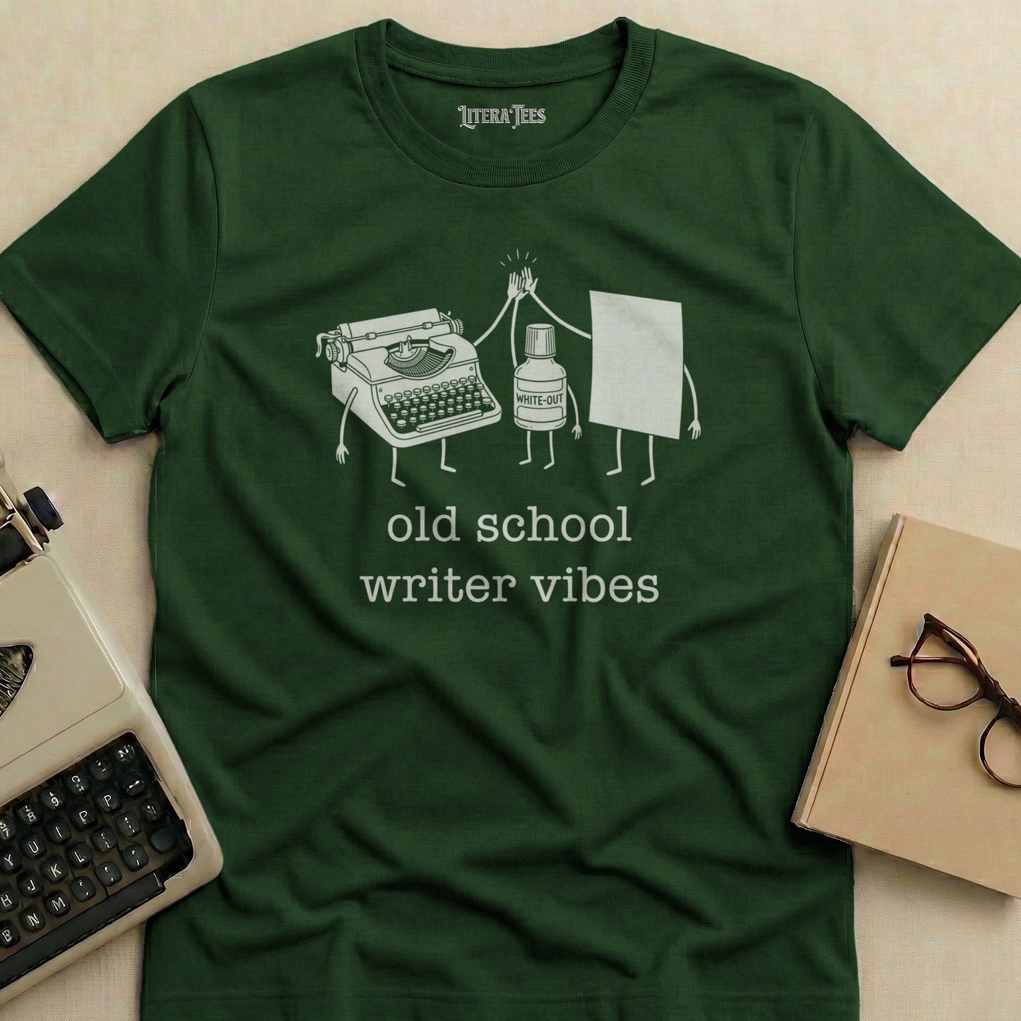 Green t-shirt with "old school writer vibes" and typewriter and correction fluid illustration.