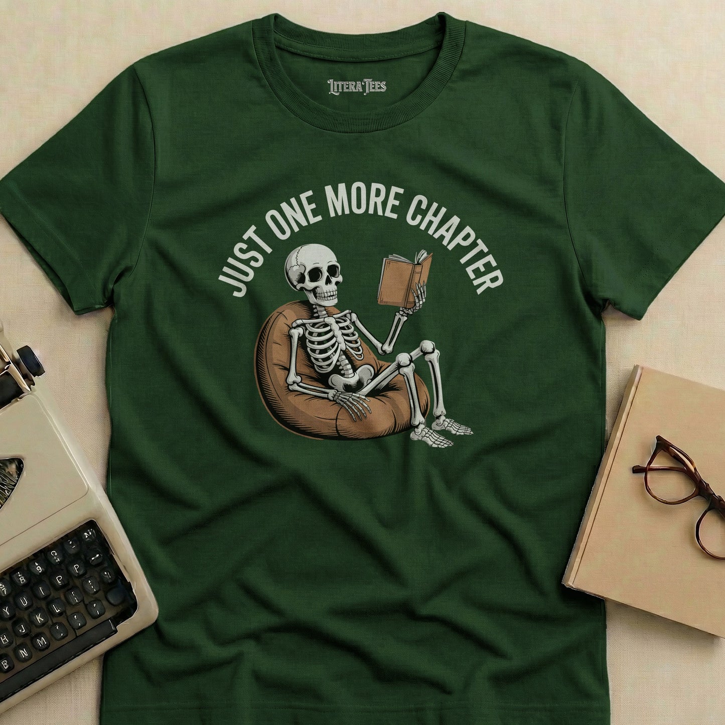Skeleton sitting in beanbag chair reading book, "JUST ONE MORE CHAPTER" text.