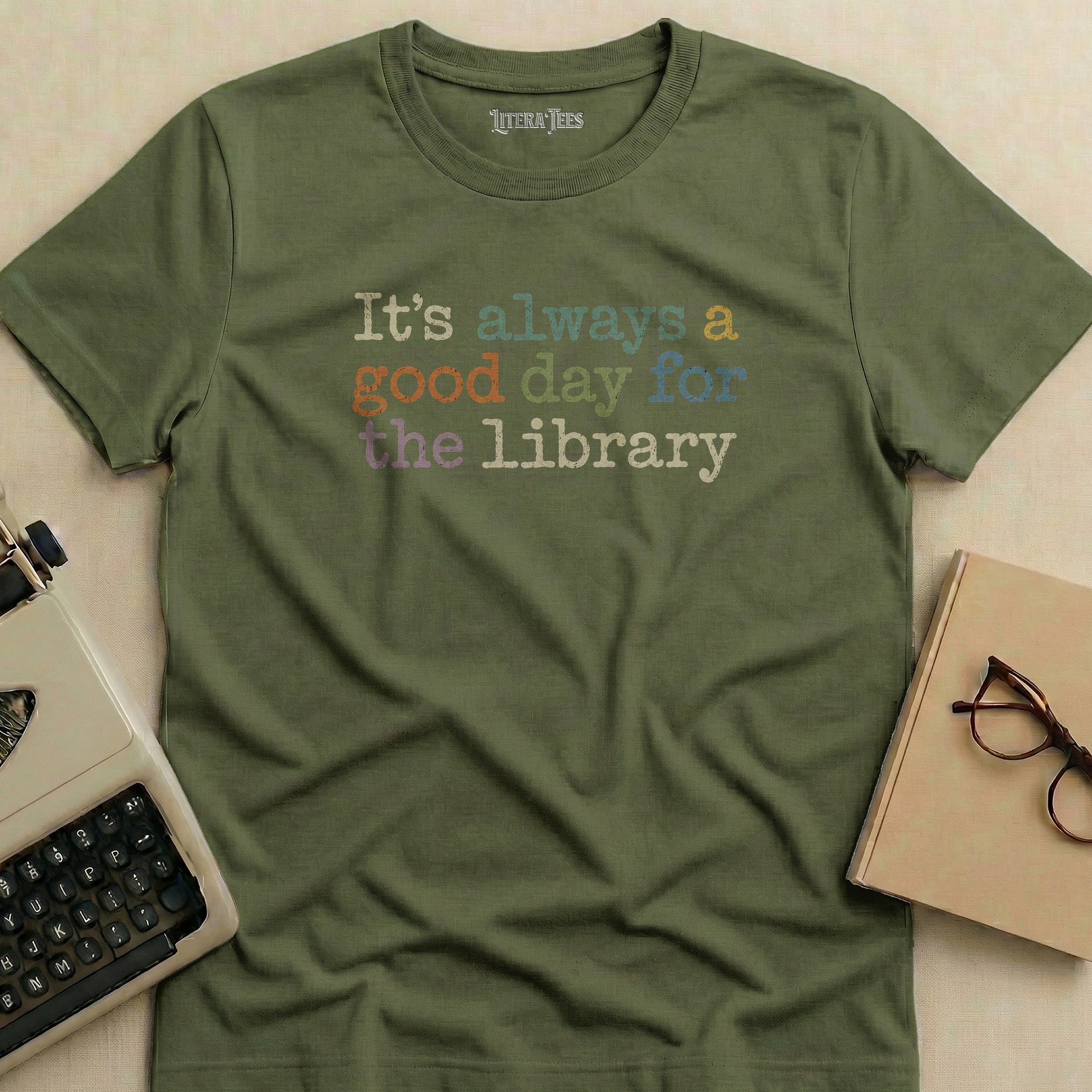 Olive green t-shirt with "It's always a good day for the library" text.