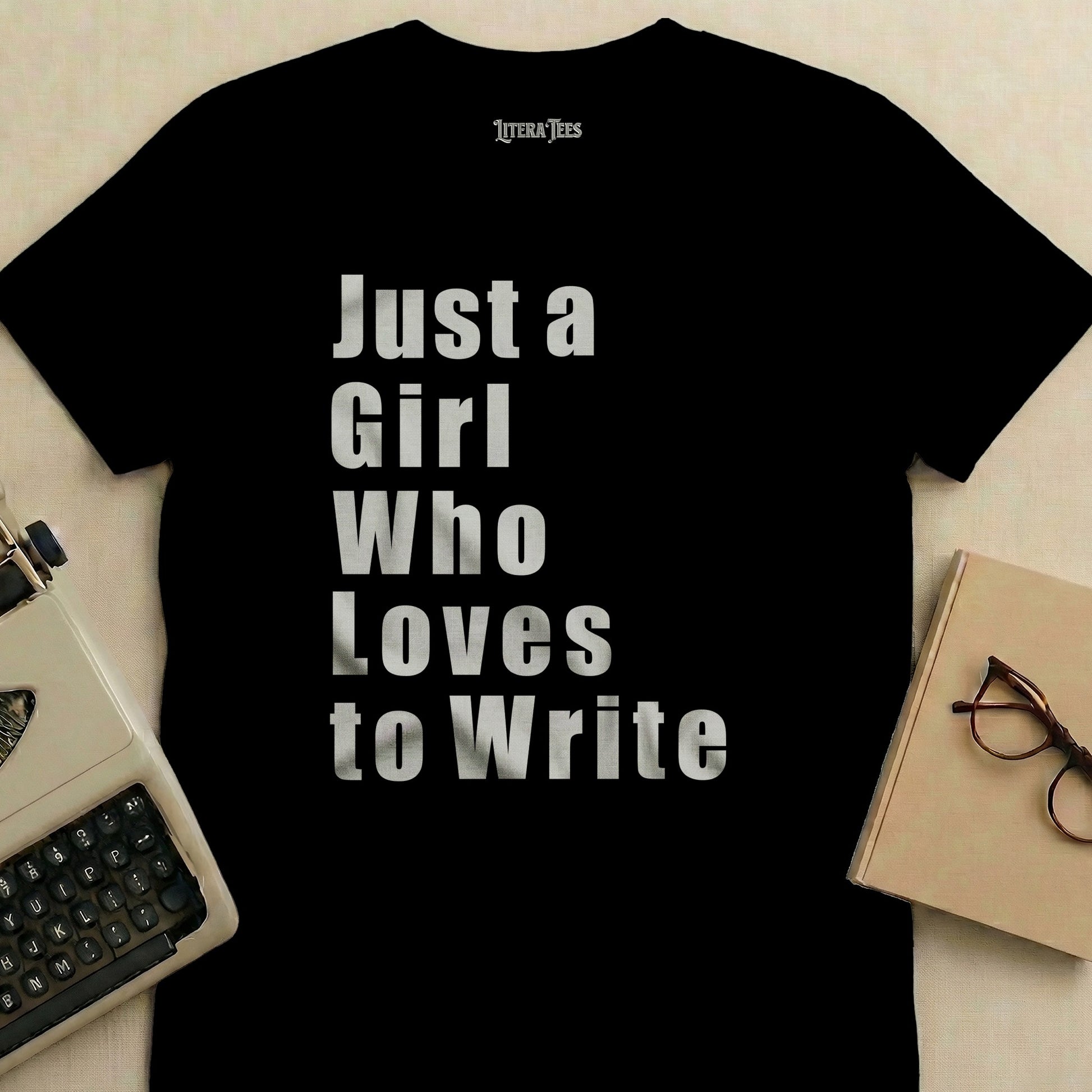 Black t-shirt with white text "Just a Girl Who Loves to Write".