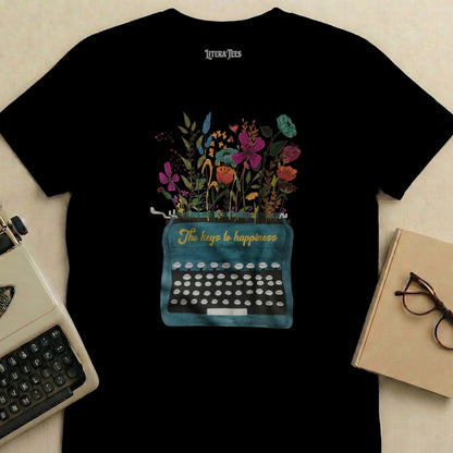 Black t-shirt with a teal typewriter graphic featuring flowers and "The keys to happiness" text.