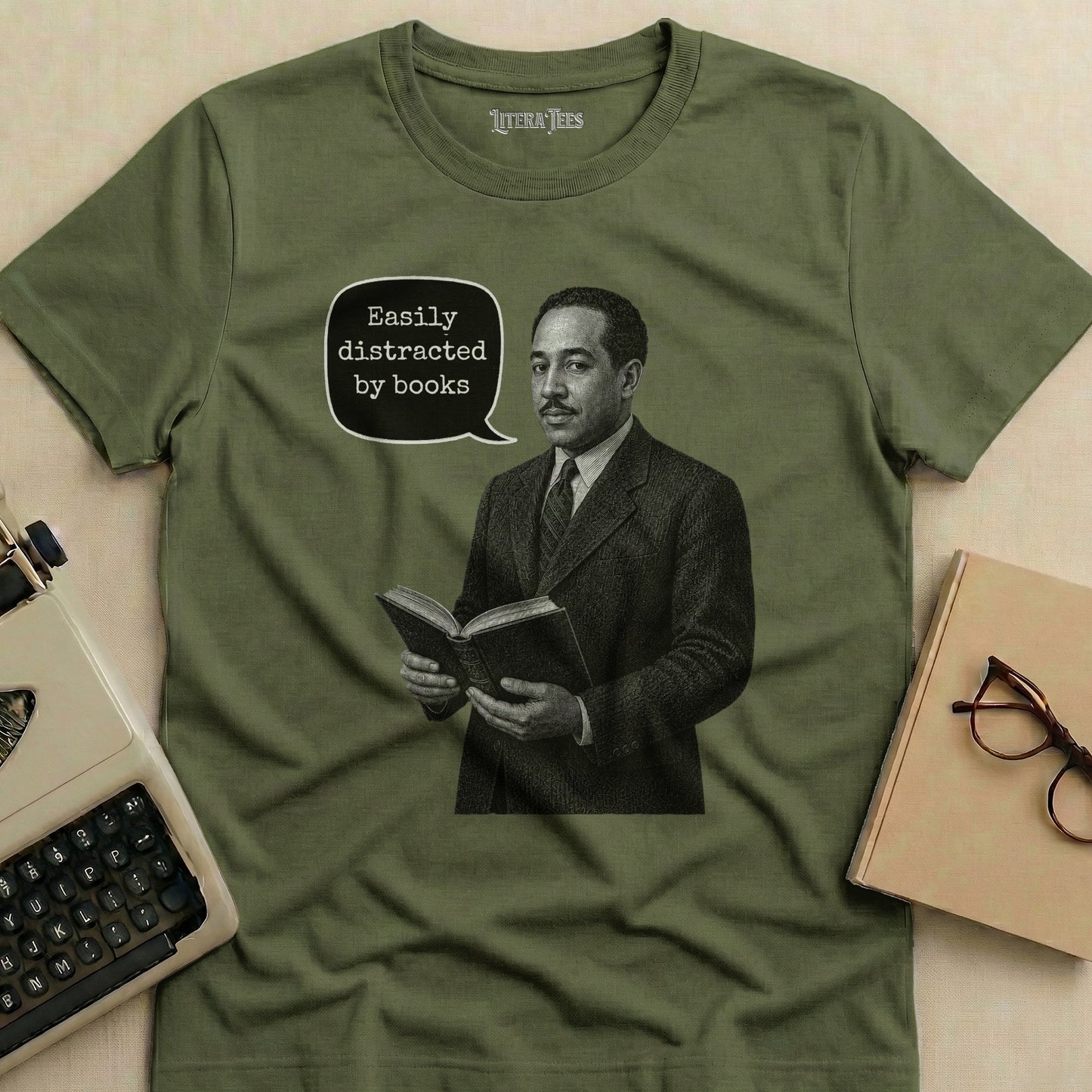 Olive green t-shirt with illustration of man reading, saying "Easily distracted by books."