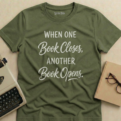 Olive green t-shirt with "When One Book Closes, Another Book Opens" text.