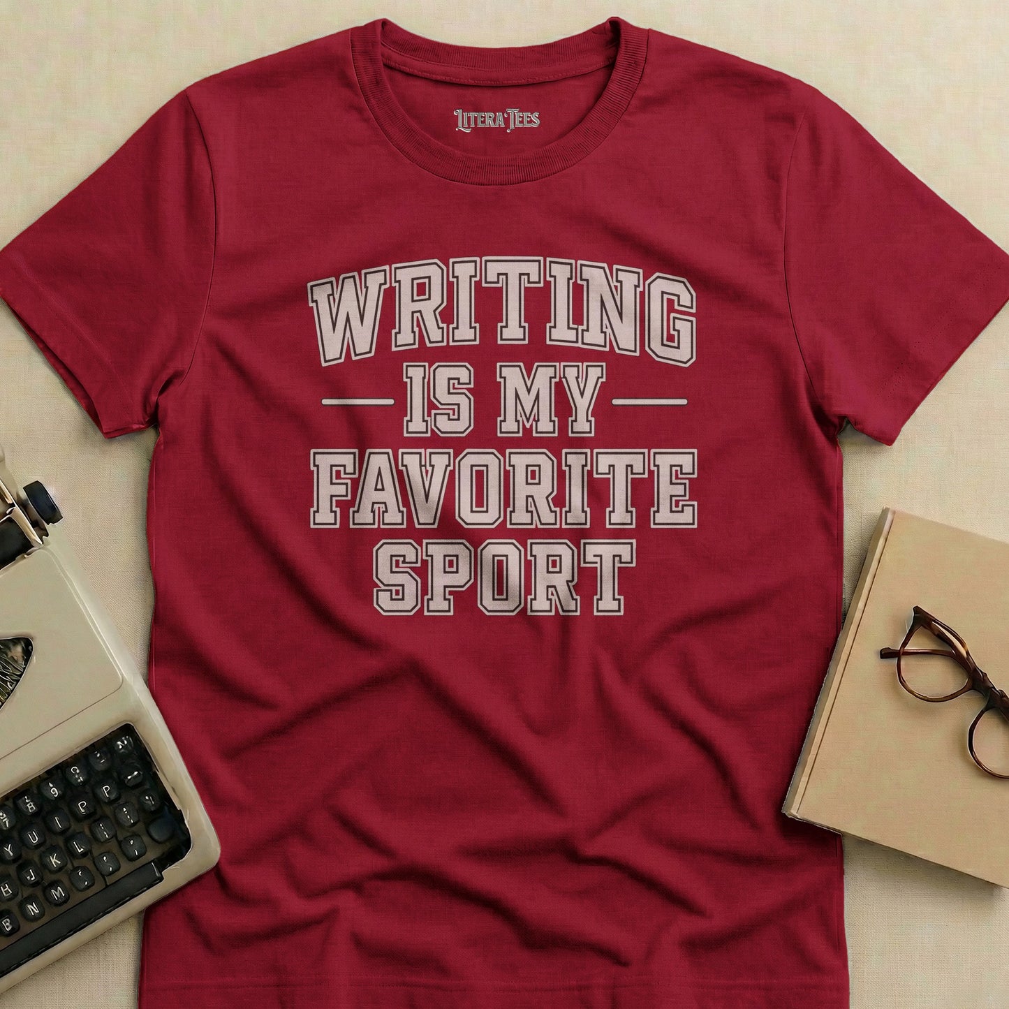 Maroon t-shirt with "WRITING IS MY FAVORITE SPORT" text.