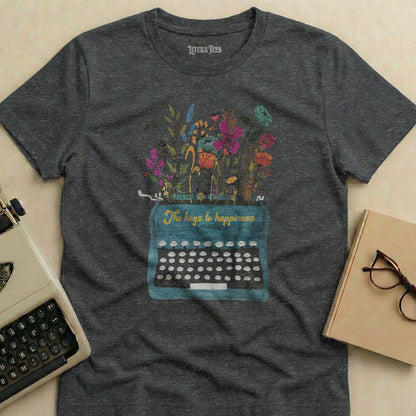 Dark t-shirt with a floral design spilling from a vintage typewriter, reading "The keys to happiness."