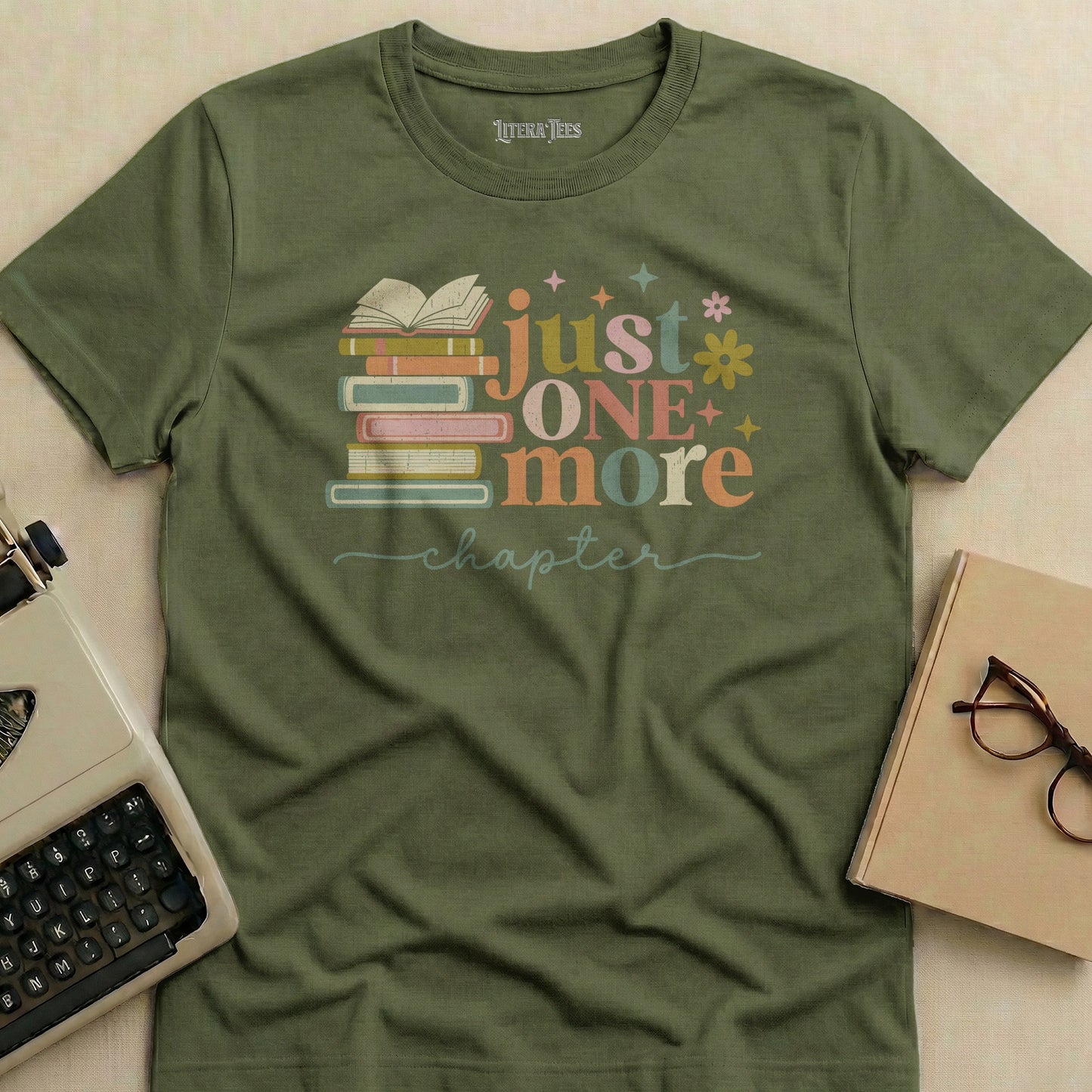 Olive green t-shirt with "just ONE more chapter" and stacked books graphic.