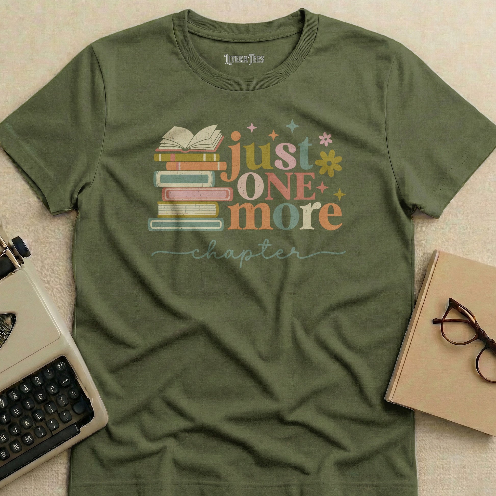 Olive green t-shirt with "just ONE more chapter" and stacked books graphic.