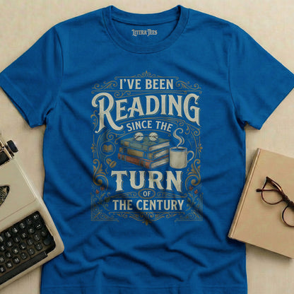 Blue t-shirt with "I've Been Reading Since The Turn of The Century" text and graphics.