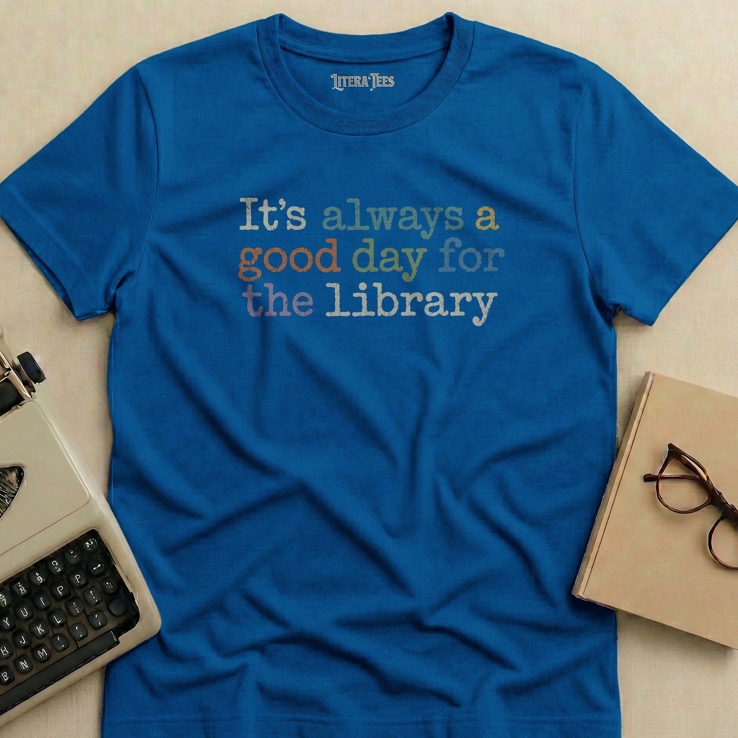 Blue t-shirt with "It's always a good day for the library" text.