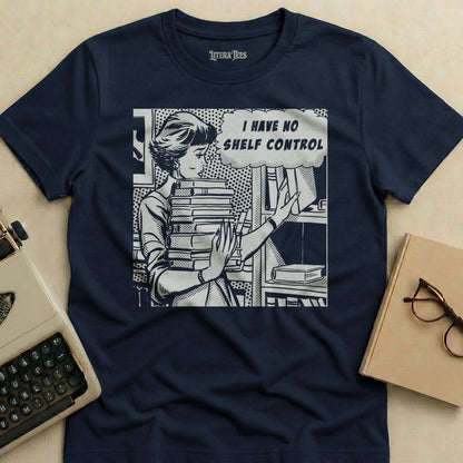 T-shirt with comic art of a woman holding a stack of books, text "I HAVE NO SHELF CONTROL".