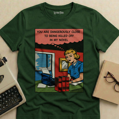 Green t-shirt with comic book style graphic: woman at typewriter, text about being killed off in a novel.